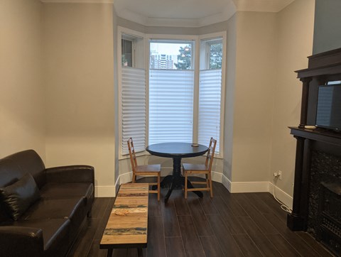 a living room with a table and chairs and a window